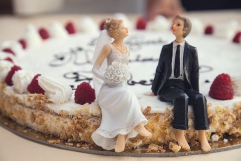 Toy versions of a married couple sitting on a groom's cake