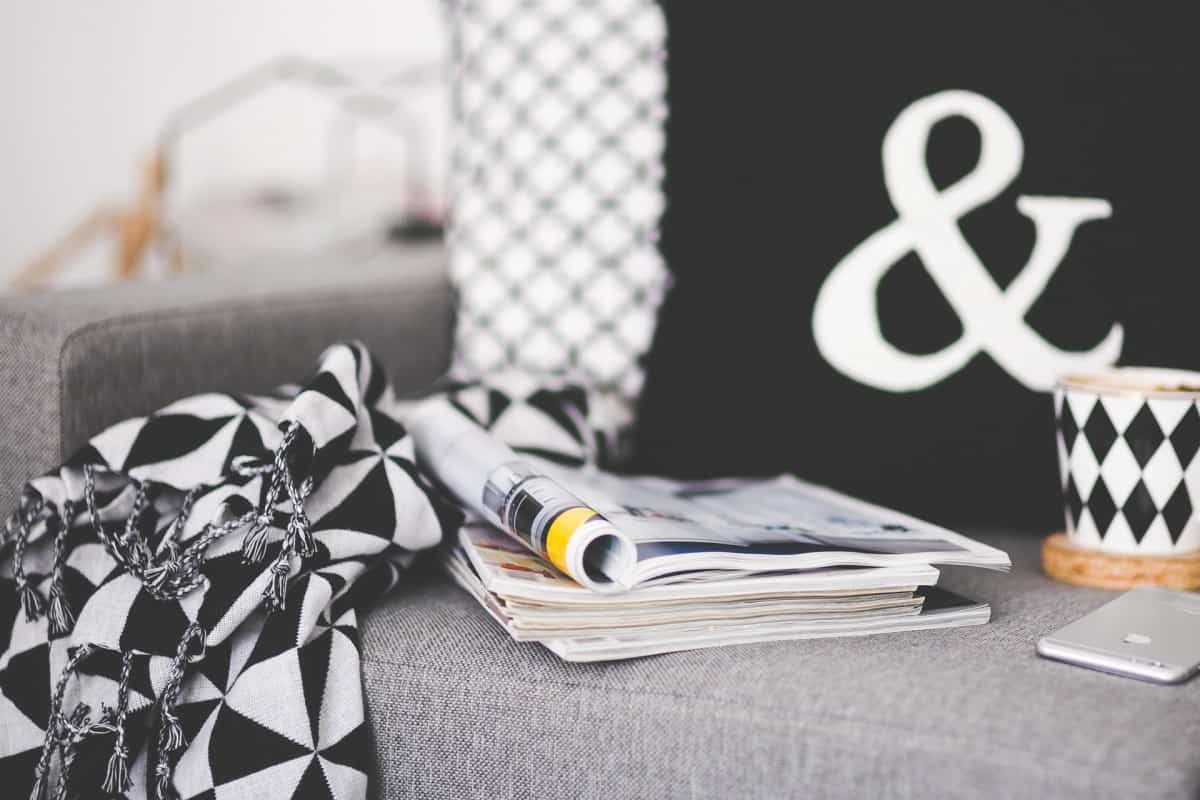 Coffee mug, blanket and magazines on a couch
