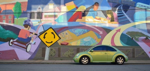 new green car in front of a colorful wall