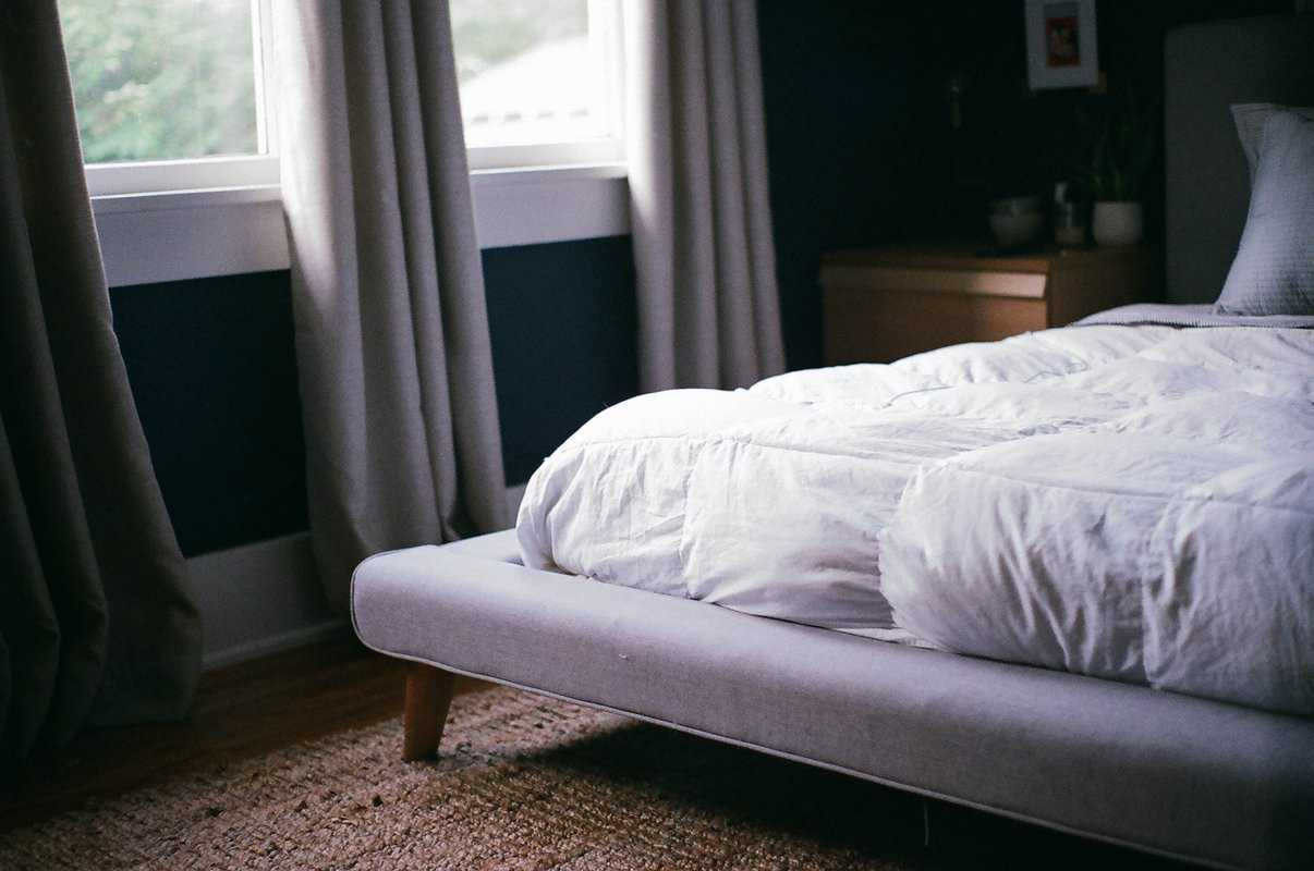 White mattress topper on bed in dark room
