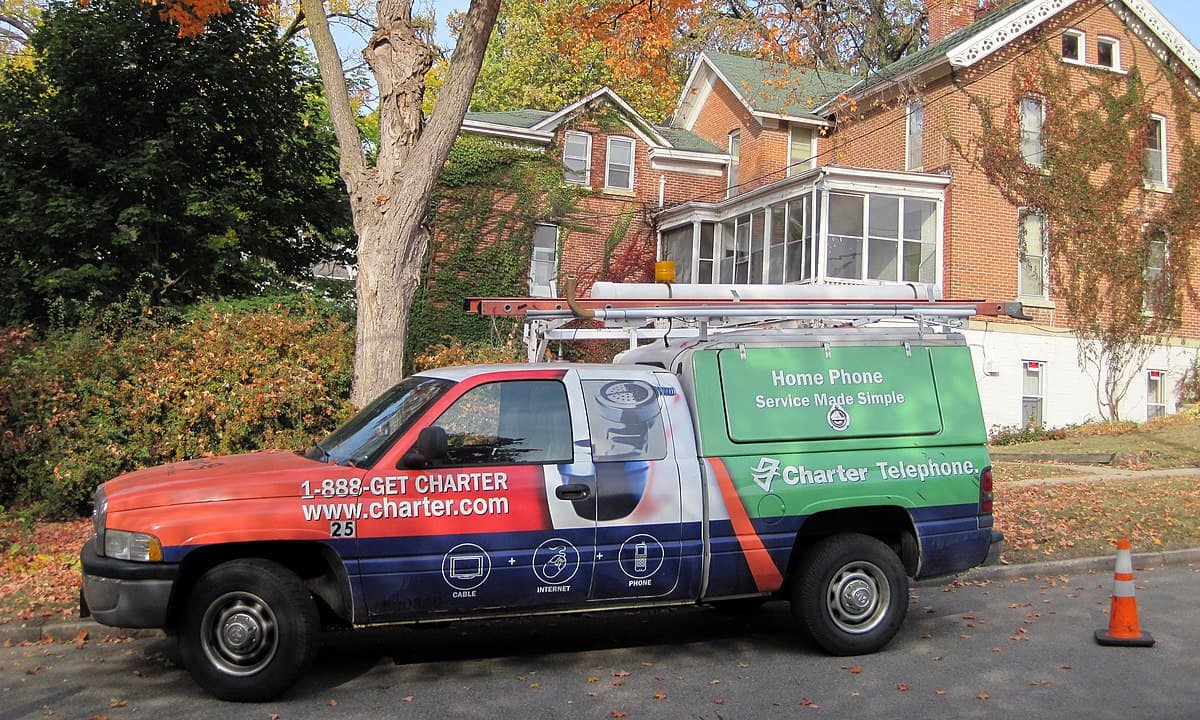 A Charter Communications company truck parked outside a house.